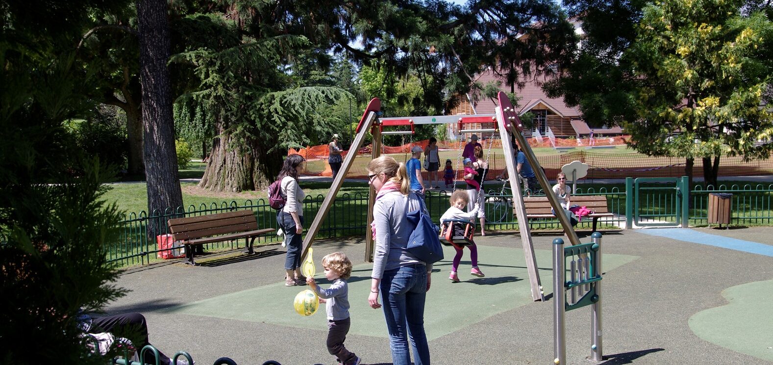 des balançoires avec des enfants dessus et des parents autours